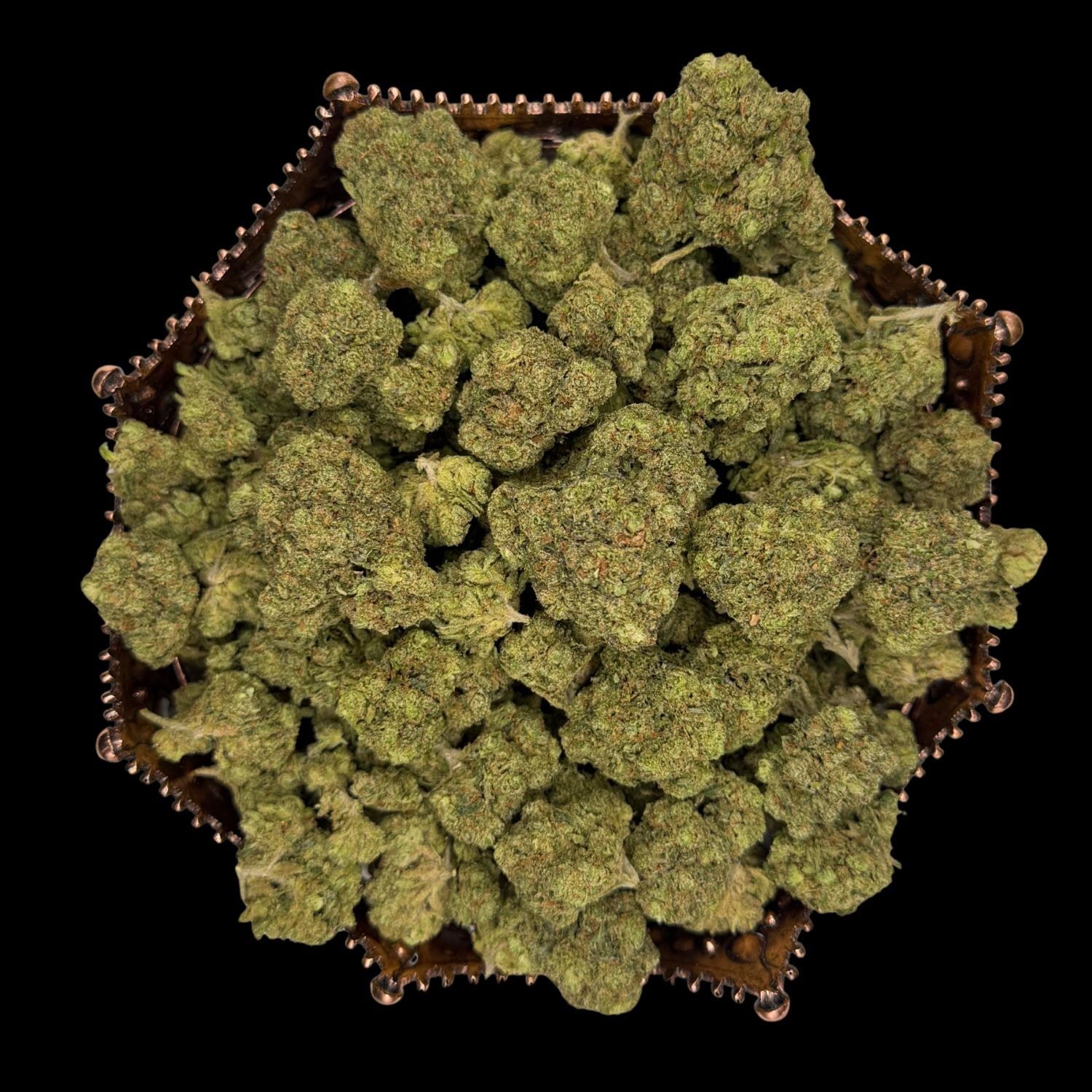 Greenhouse THCA flower buds arranged in a hexagonal copper tray, photographed on black